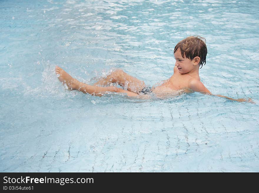 Young boy playing in water pool. Young boy playing in water pool