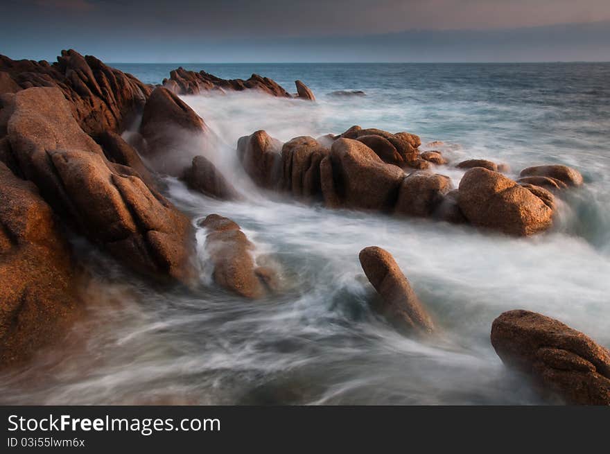 Motion blurred sea on rocky coast