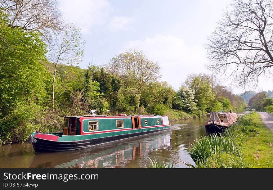 A gaily painted narrrowboat traverses the Kennet and Avon canal, Britain. A gaily painted narrrowboat traverses the Kennet and Avon canal, Britain