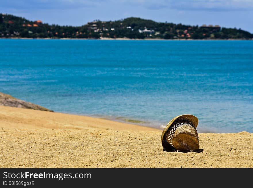 Hat on white sand of coast