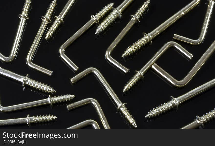 a background of L-shaped metal hooks on a black background. a background of L-shaped metal hooks on a black background