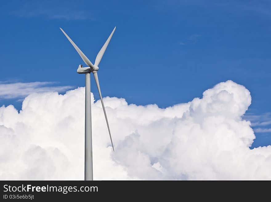 Wind turbine generating electricity with a nice white cloud on the sky