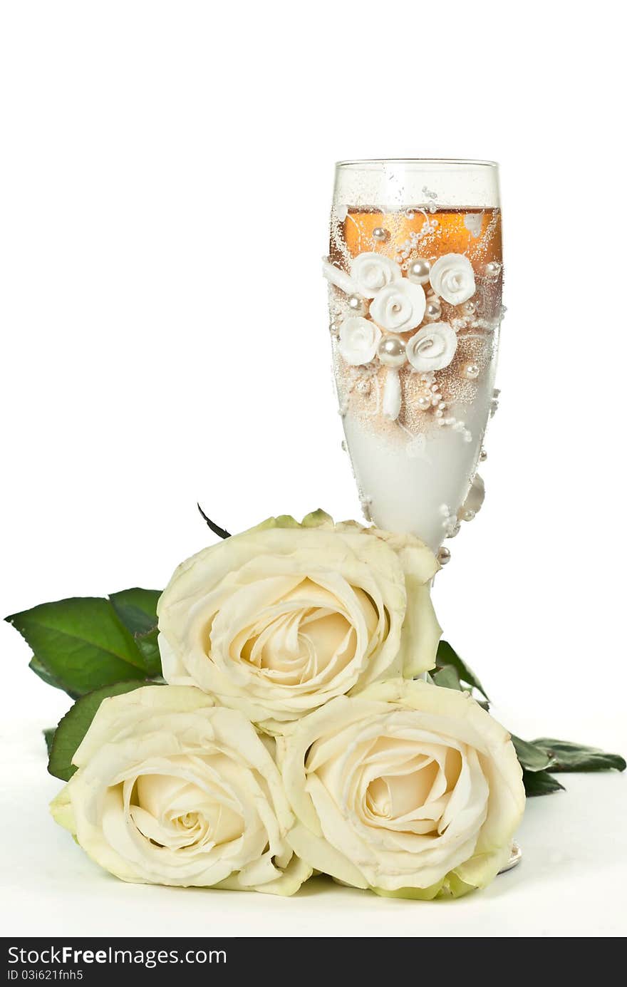 One glass of celebratory champagne with white roses. One glass of celebratory champagne with white roses