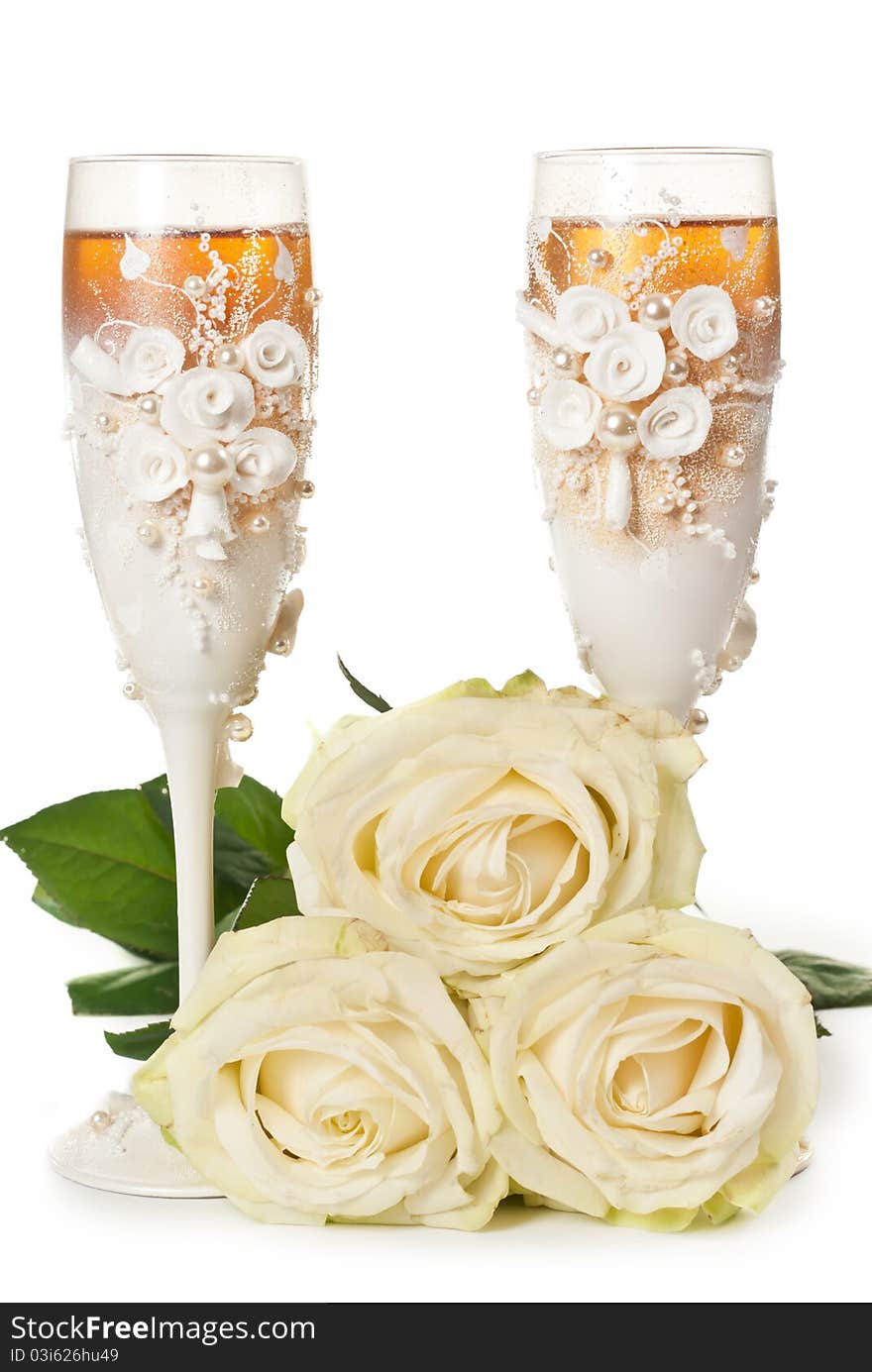 Two glasses of celebratory champagne with white roses. Two glasses of celebratory champagne with white roses