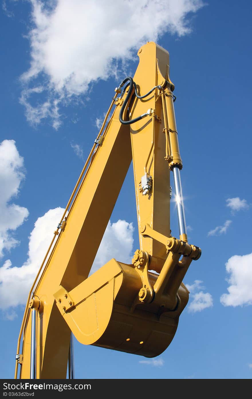 Yellow ladle of a dredge against the blue sky