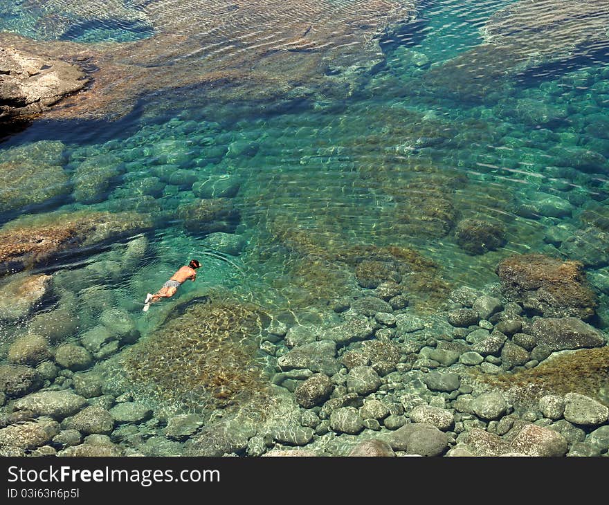 People diving in a natural basin in the rocks coastline of Lanzarote