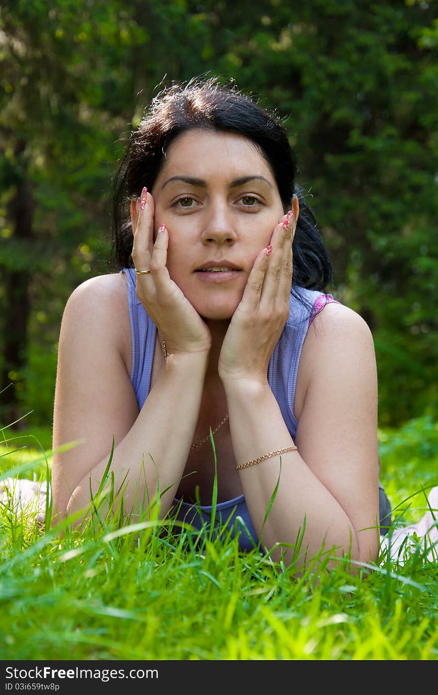 Beautiful middle-aged woman lying on grass