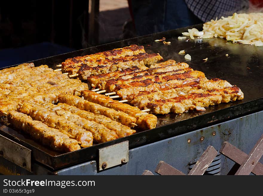 Kebabs being cooked on a barbecue hotplate