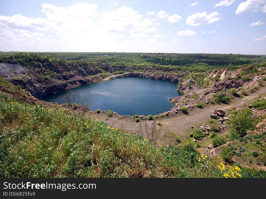 Landscape with blue deep lake in large granite open pit. Landscape with blue deep lake in large granite open pit