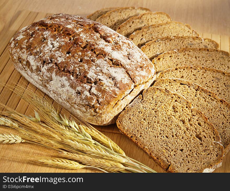 Freshly baked bread and wheat on table