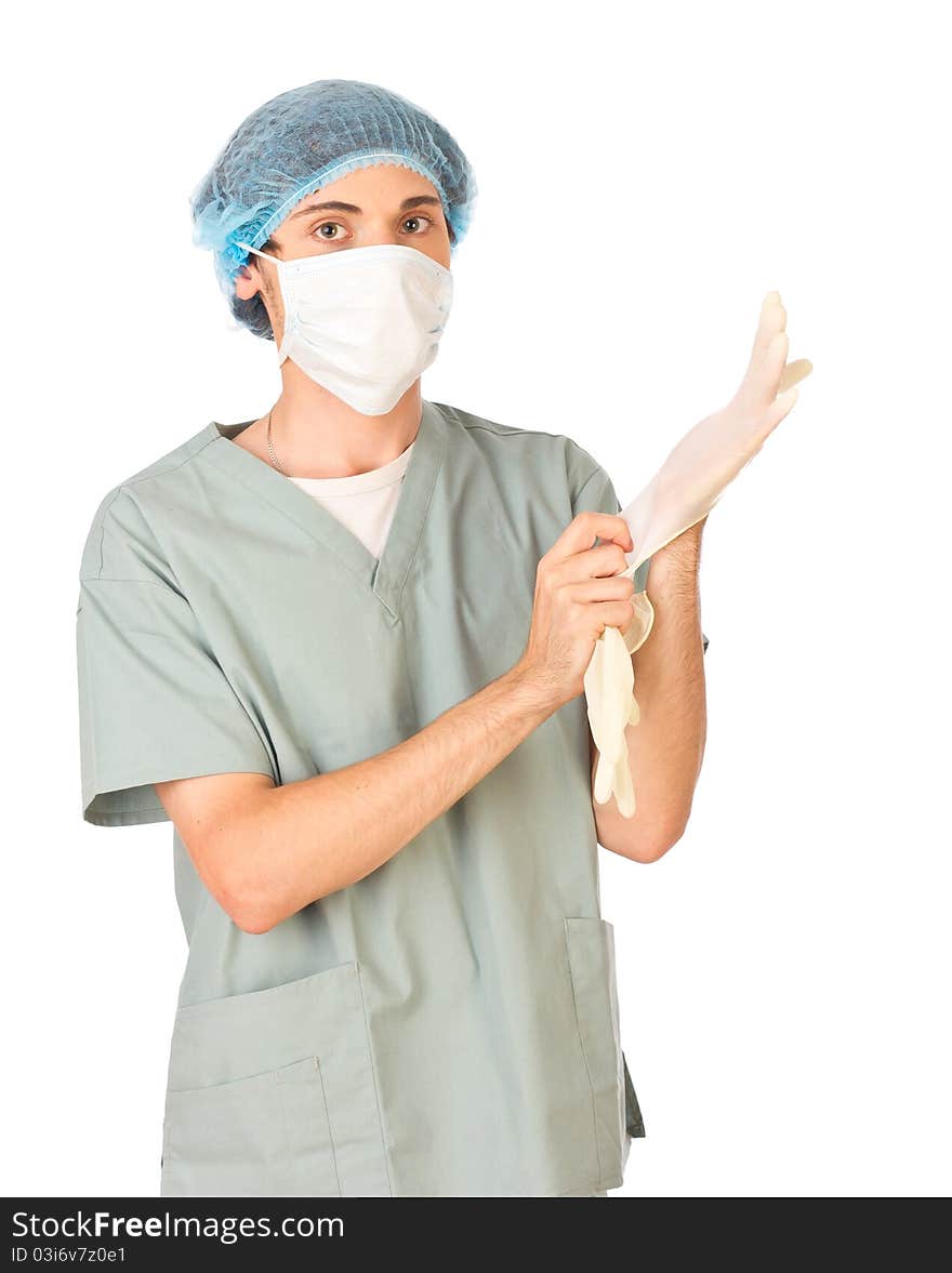 Young medical worker in mask standing and putting on gloves. Young medical worker in mask standing and putting on gloves