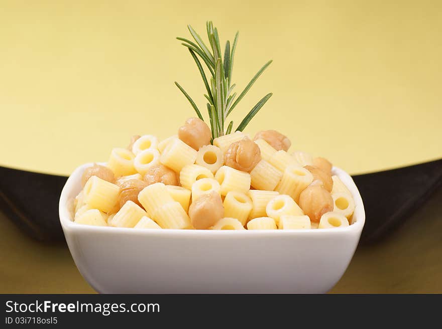 Small thimbles (ditalini) with chickpea and rosemary served in a white plate. Small thimbles (ditalini) with chickpea and rosemary served in a white plate