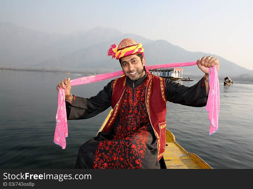 Pathani boy (North Indian) in tradition burqa dress sitting on a shikara boat and dancing to a folk song with a pink shawl in hand. Pathani boy (North Indian) in tradition burqa dress sitting on a shikara boat and dancing to a folk song with a pink shawl in hand