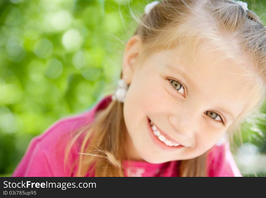 Cute little girl smiling in a park close-up