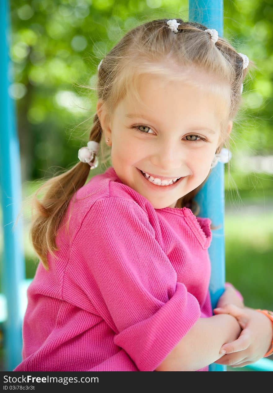 Cute little girl smiling in a park close-up