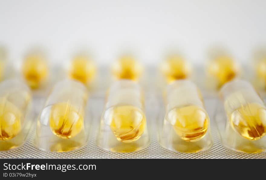 Plastic and foil blister with rows of yellow gel pills. Plastic and foil blister with rows of yellow gel pills