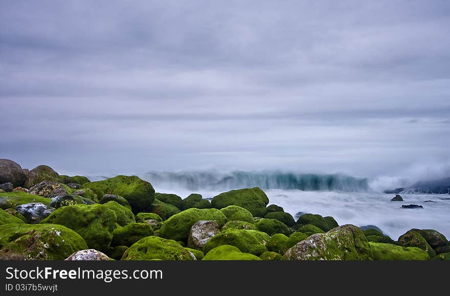 Green stones in beach and great wave. Green stones in beach and great wave