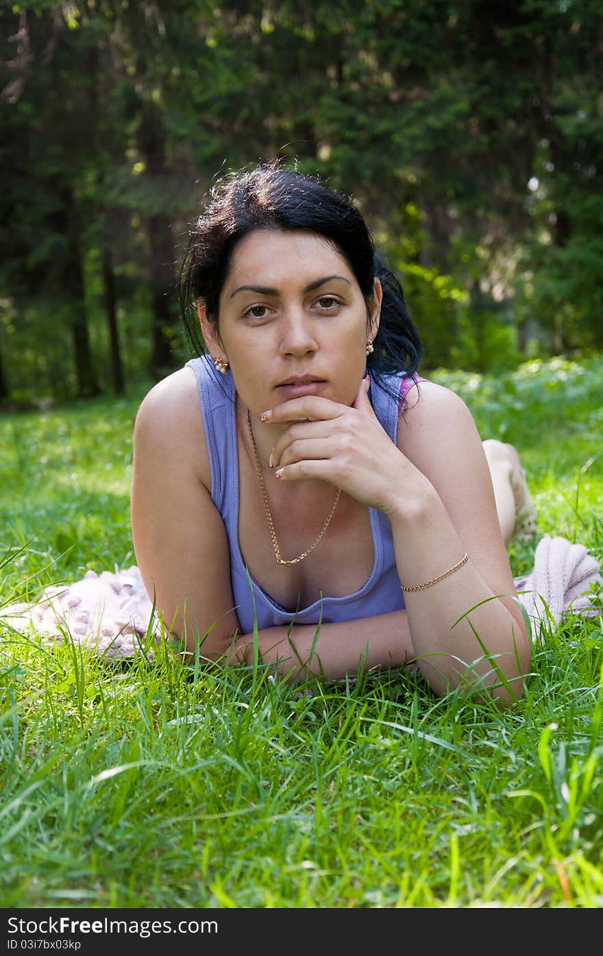 Beautiful middle-aged woman lying on grass