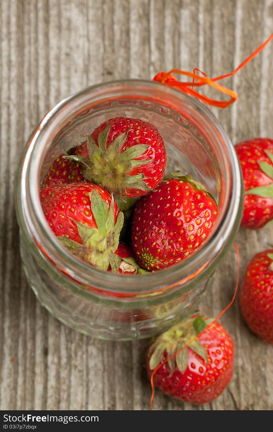 Top view on pot of fresh strawberry on old wooden table