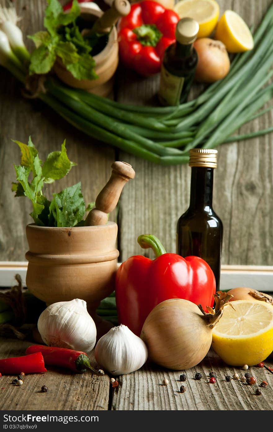 Vintage mortar and vegetables paprika, pepper and garlic on old wooden tabe with reflex in mirror. Vintage mortar and vegetables paprika, pepper and garlic on old wooden tabe with reflex in mirror