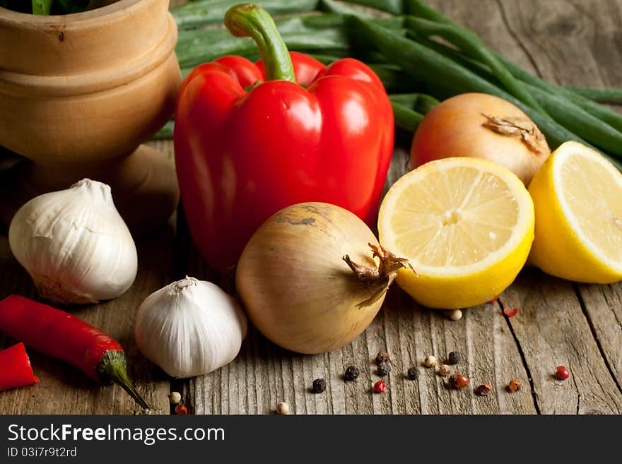 Onion, red paprika, garlic, lemon and chili pepper on old wooden table. Onion, red paprika, garlic, lemon and chili pepper on old wooden table