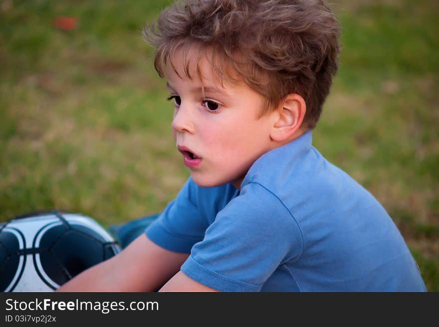 Cute little boy with a ball in a park . Cute little boy with a ball in a park .