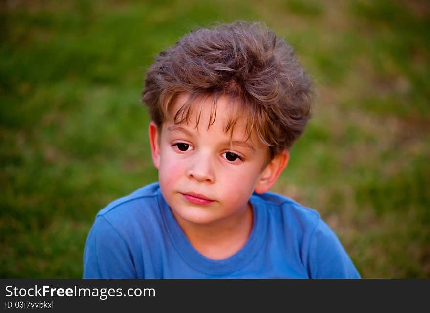 Portrait of happy joyful beautiful little boy against the background of grass . Portrait of happy joyful beautiful little boy against the background of grass .