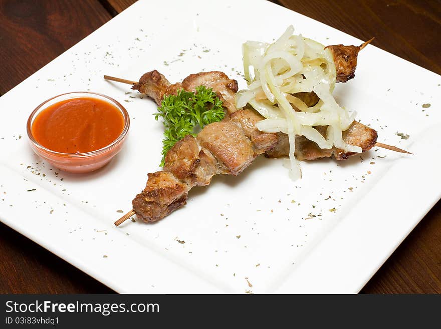 Meat on skewers, onion and sauce