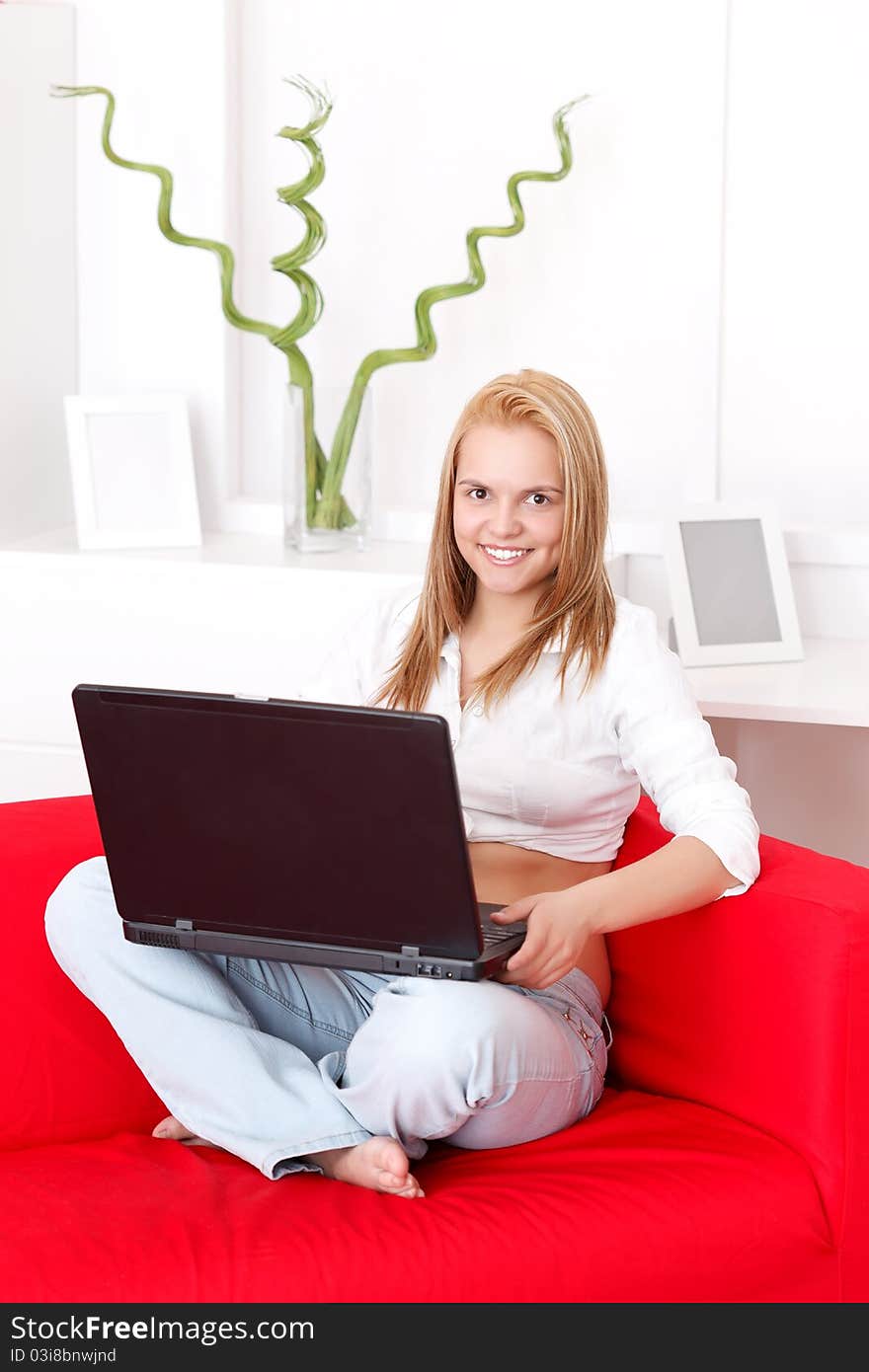 Young woman using her laptop from home. Young woman using her laptop from home