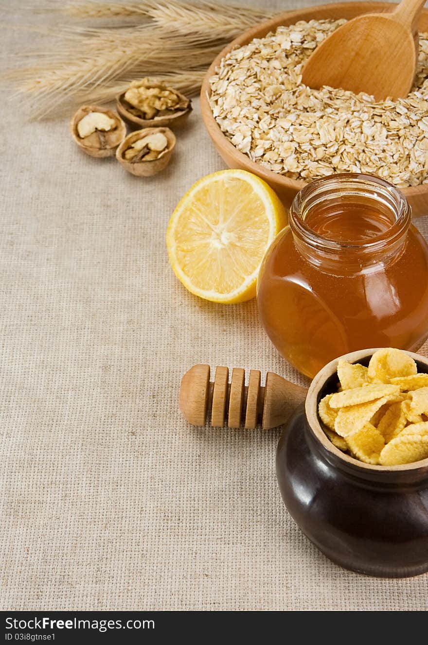 Plate of oat, honey and healthy food on sacking