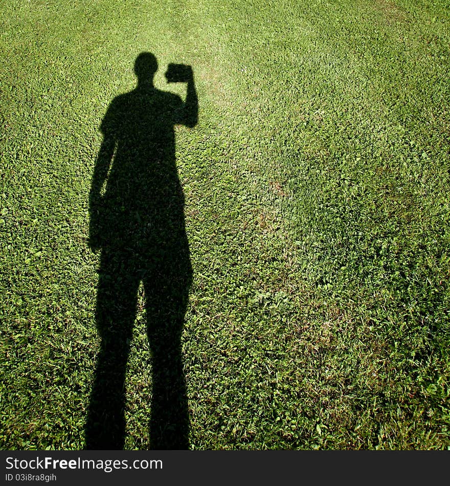 Shadow of photographer standing on grass. Shadow of photographer standing on grass