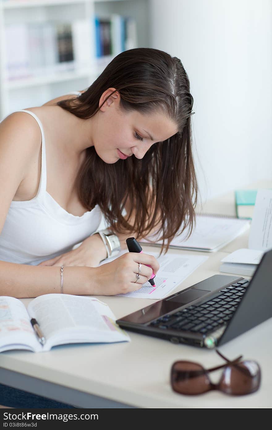 Pretty female college student in the  library