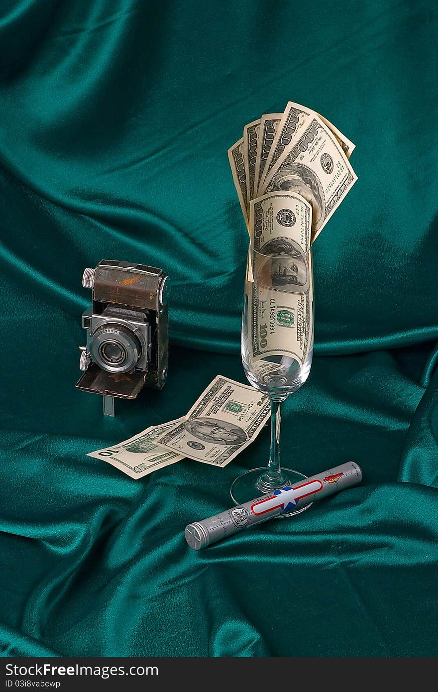 Composition shot of money, camera and cigar