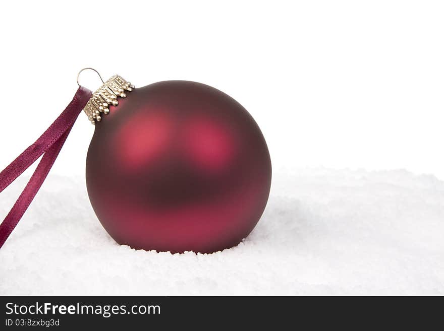 A Red Christmas Bauble on Snow Background. A Red Christmas Bauble on Snow Background