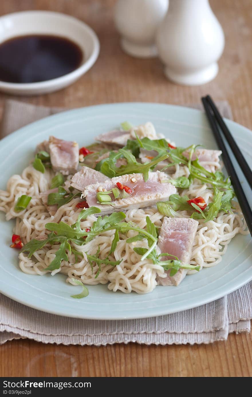 Tuna steak with wasabi noodles and rocket on a plate. Tuna steak with wasabi noodles and rocket on a plate