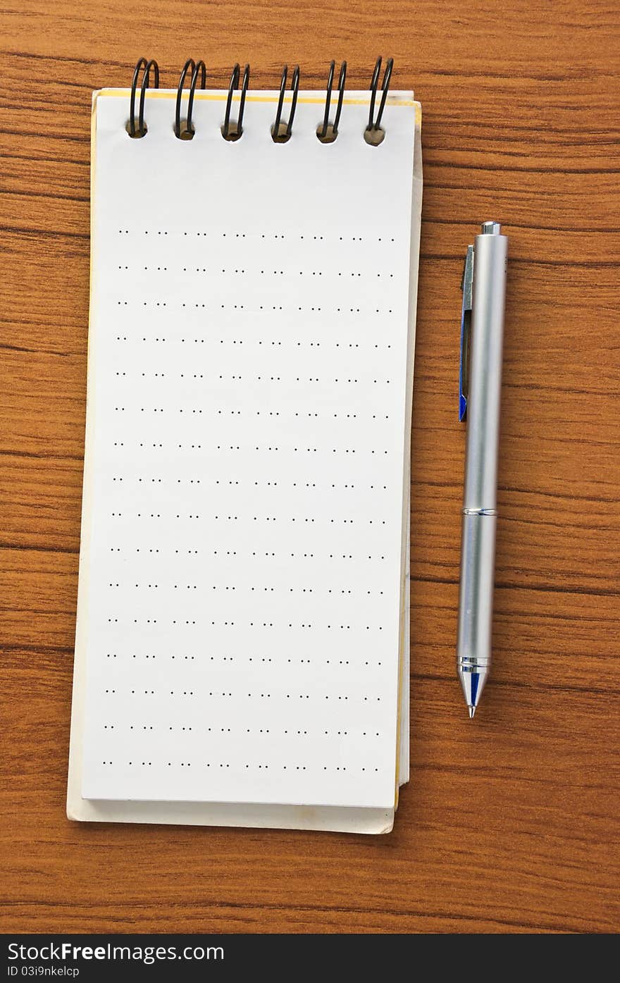 Blank notepad with pen on wood table