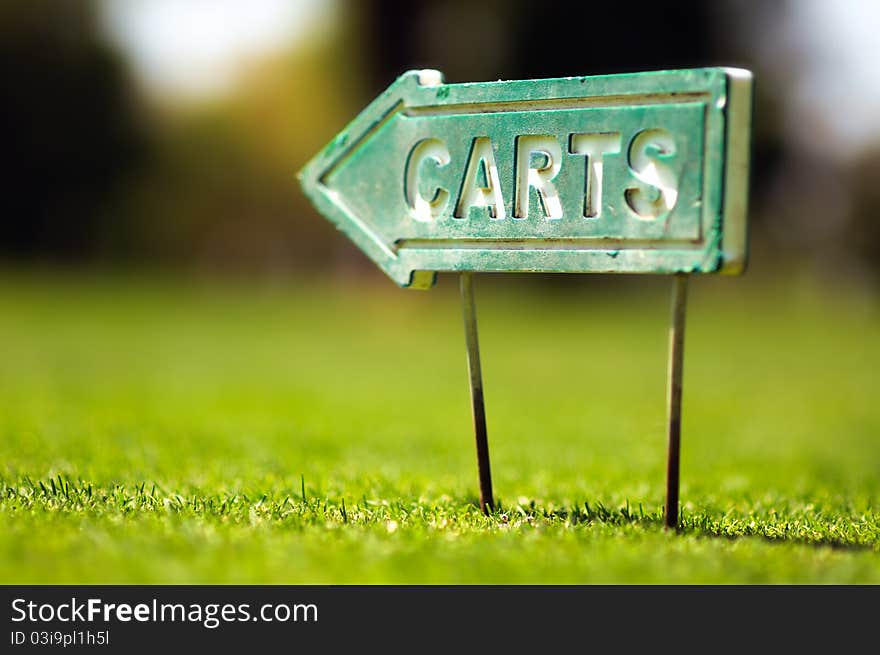 Golf carts sign on a golf field. Small depth of field.