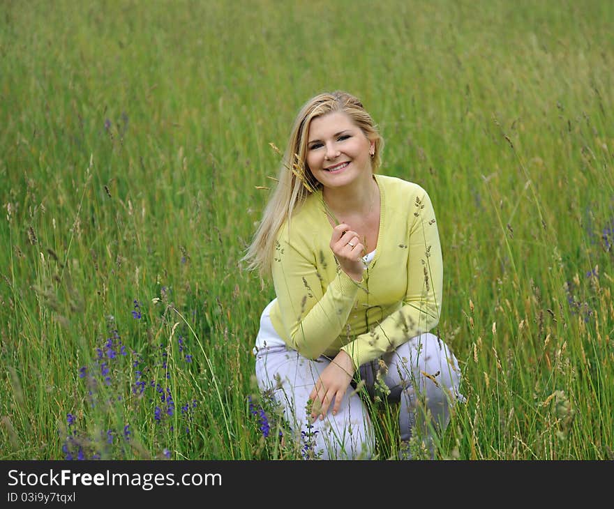 Pretty healthy summer woman outdoors on green field in Alps enjoying freedom. Switzerland