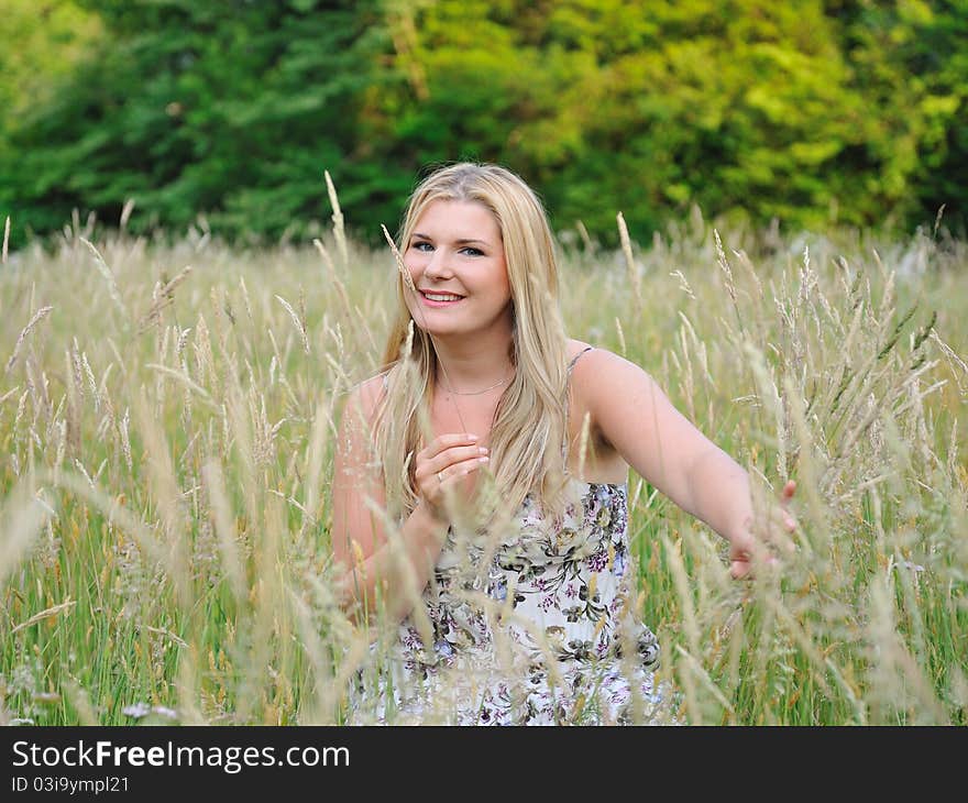 Pretty summer woman on yellow wheat field