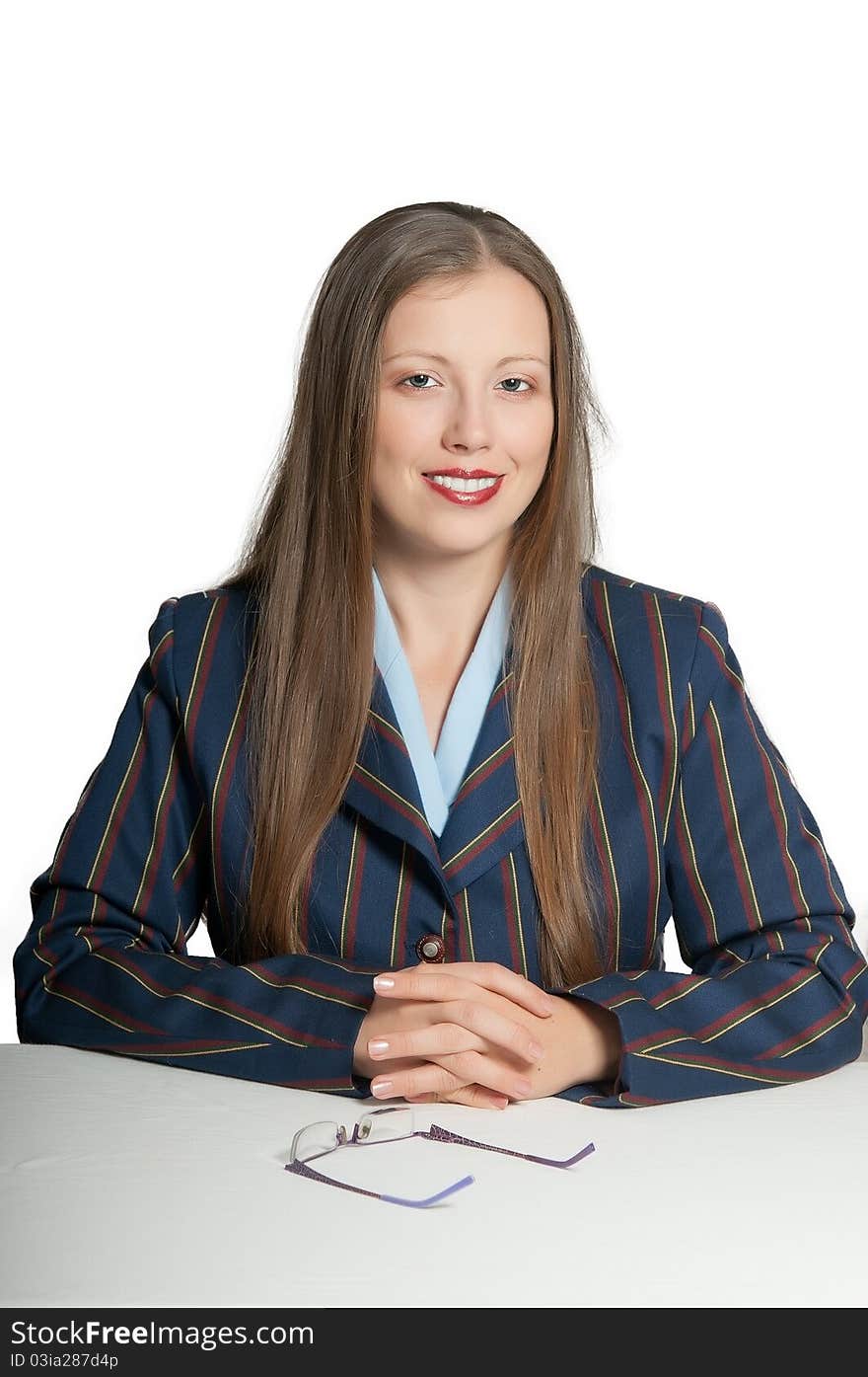 Young girl smiling manager sits behind a white desk, glasses on the table