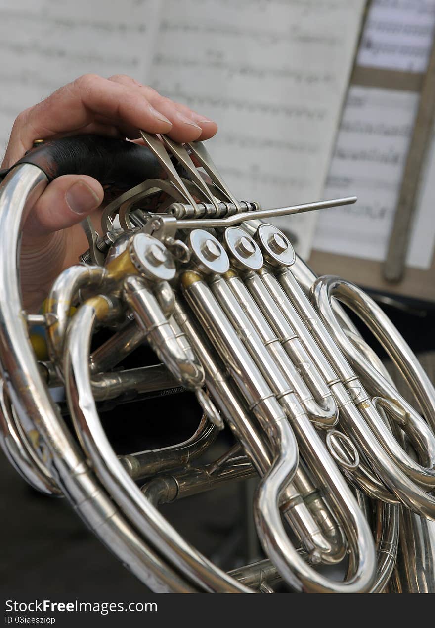 Detail of a musicians fingers playing a horn. Detail of a musicians fingers playing a horn.