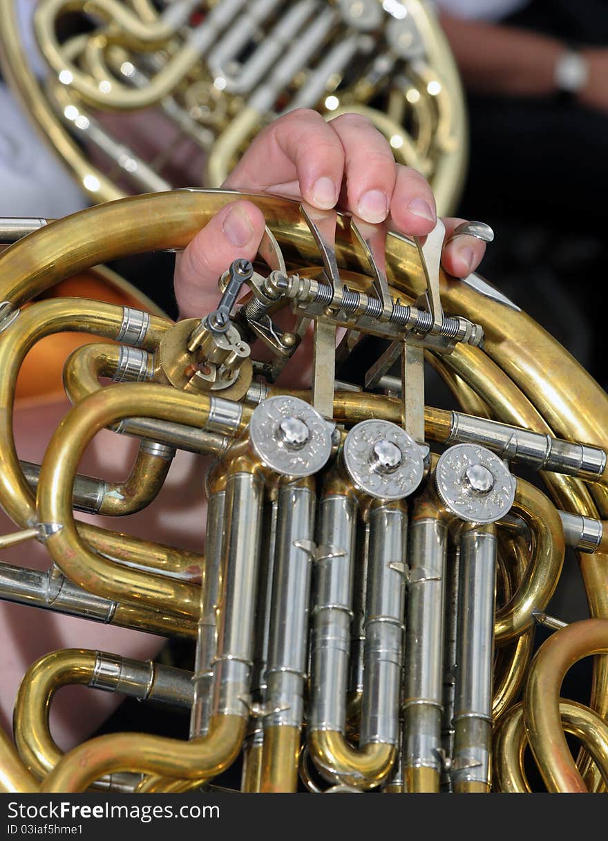 Detail of a musicians fingers on a brass horn. Detail of a musicians fingers on a brass horn.