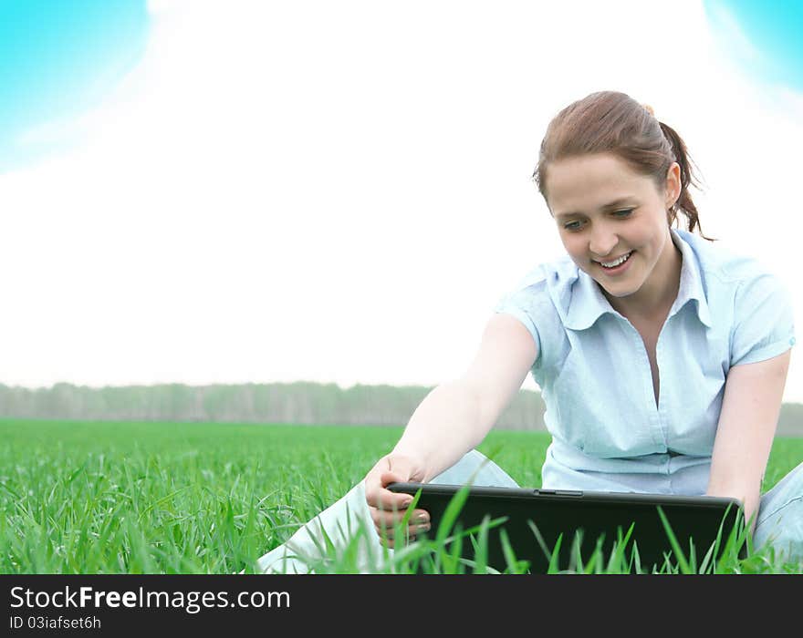 Girl sitting in the grass with laptop