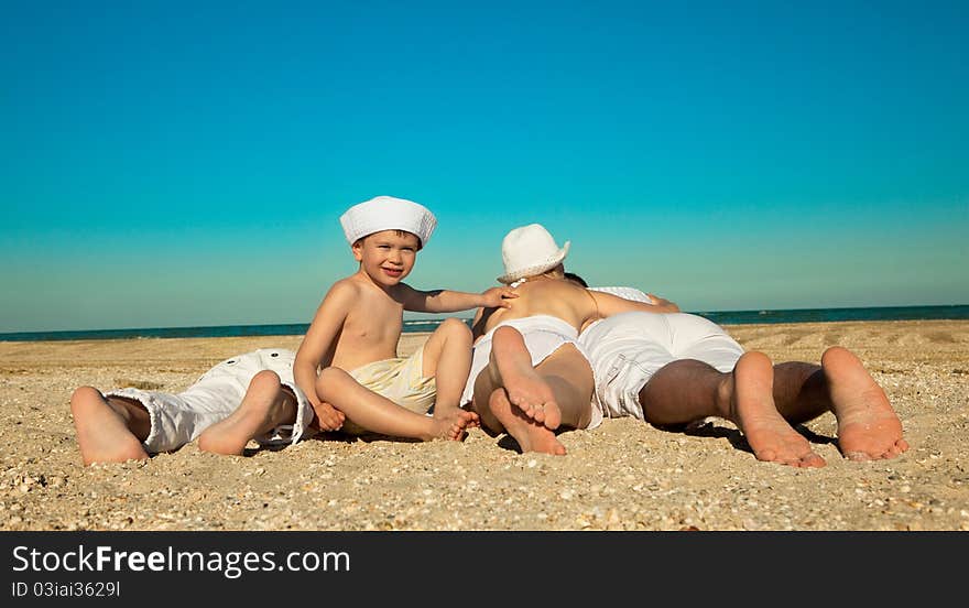 Photo of family lying on sand on background of blue sky