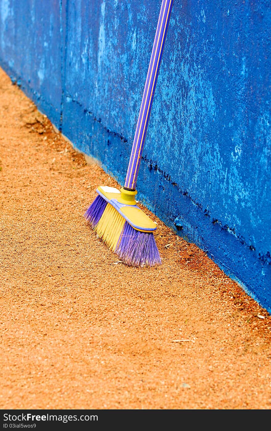 The Plastic besom on sand near concrete wall