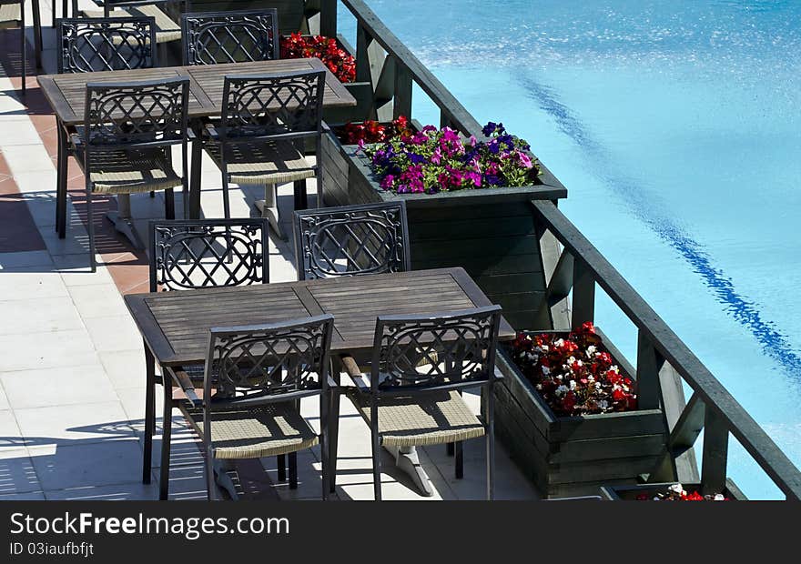 Dinner tables near a pool with flovers. Dinner tables near a pool with flovers