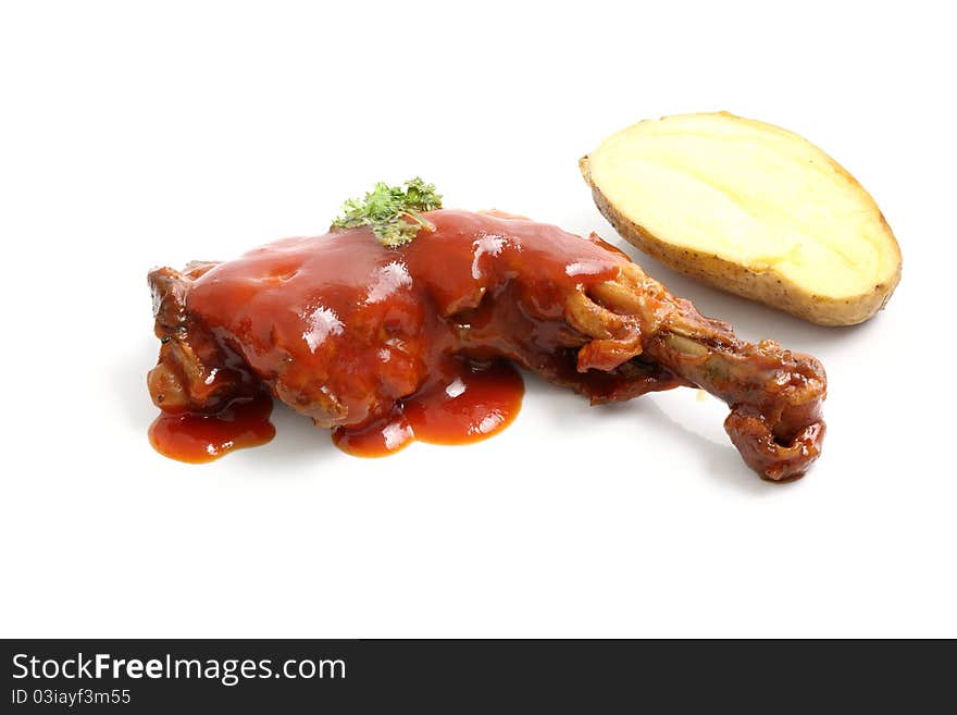 Cooked chicken wings in a sauce and potato isolated in white background