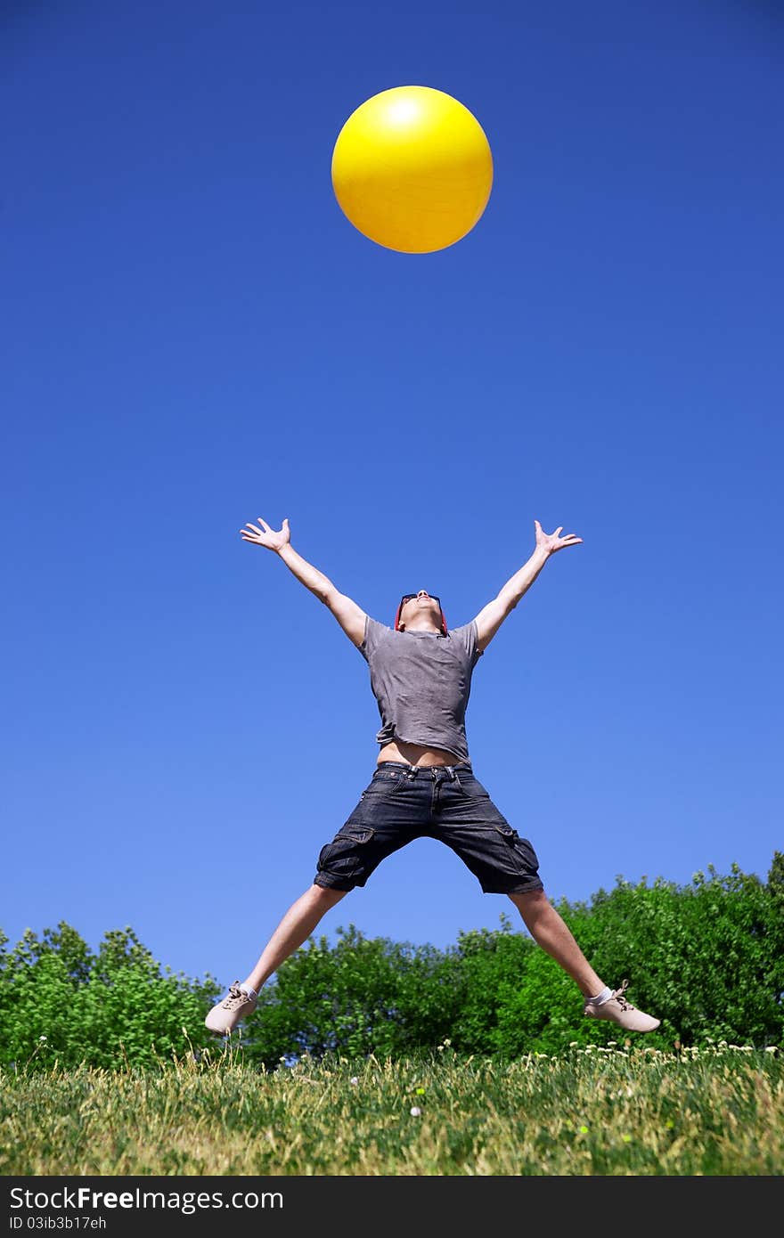 Young man jump in park with yellow ball. Young man jump in park with yellow ball