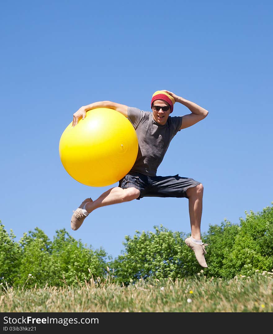 Young man jump in park with yellow ball. Young man jump in park with yellow ball