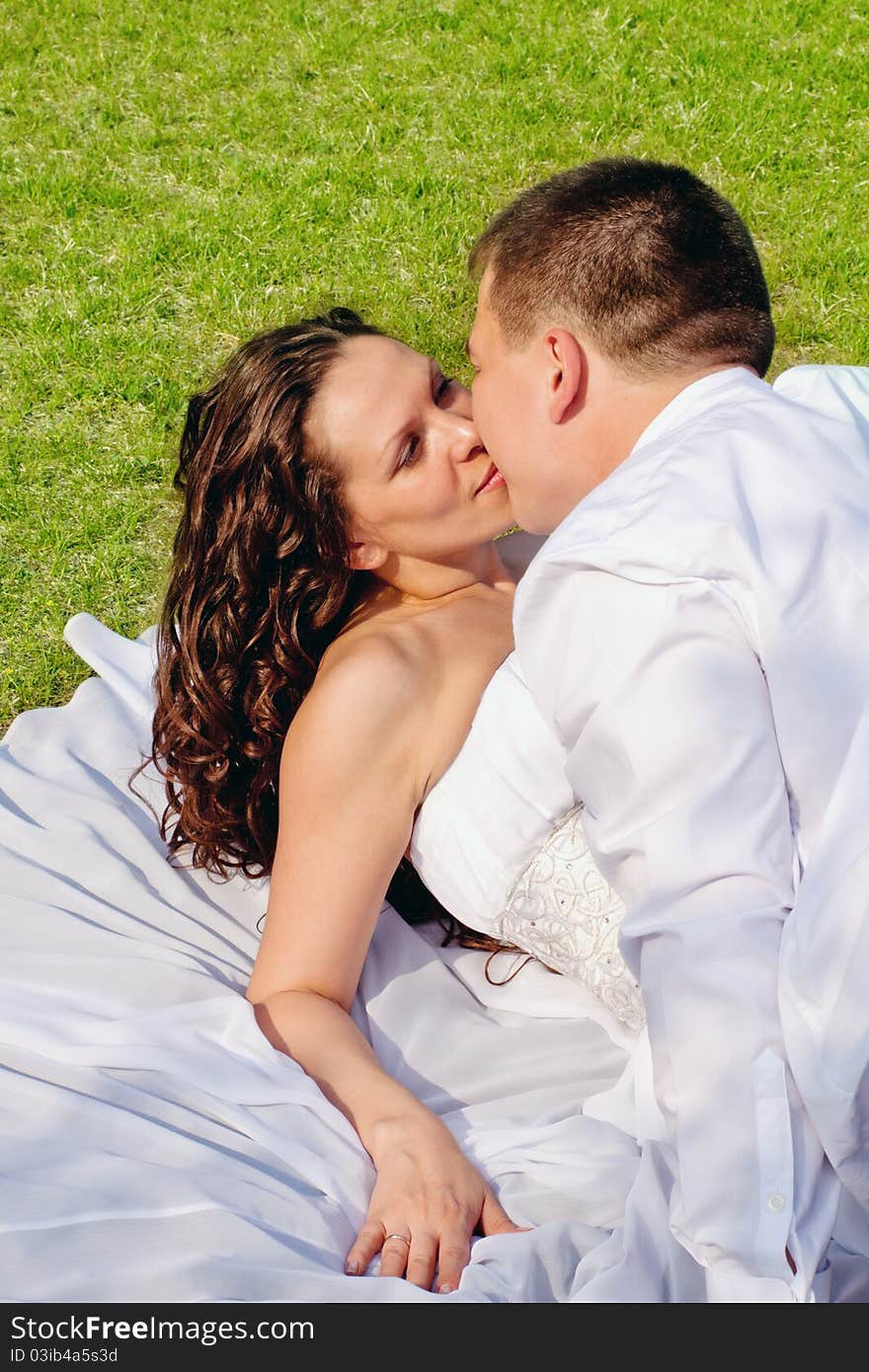 A couple on their wedding day kissing and laughing. A couple on their wedding day kissing and laughing